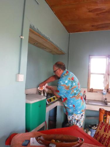 a man standing in a kitchen preparing food at Jinack Lodge in Jinack Island