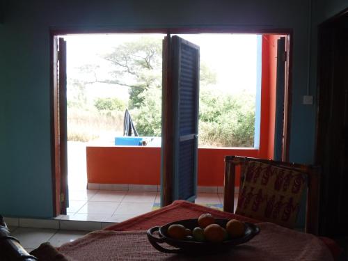 a bowl of fruit on a table in front of a door at Jinack Lodge in Jinack Island