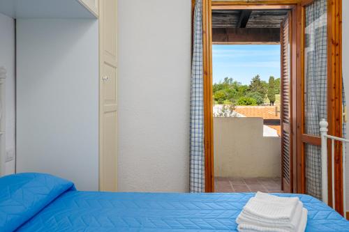 um quarto com uma cama e uma porta para uma varanda em San Paolo House em Porto San Paolo