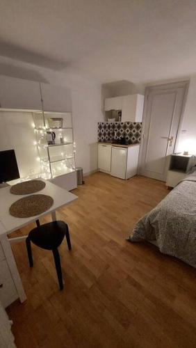 a living room with a bed and a table and a kitchen at Studio cosy in Lons-le-Saunier