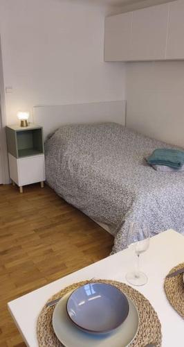 Un dormitorio con una cama y una mesa con un plato. en Studio cosy, en Lons-le-Saunier