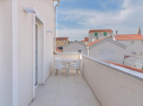 a balcony with a table and chairs on it at Šangulin Palace V in Biograd na Moru