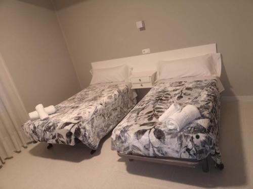 2 camas en una habitación pequeña con faldas en Hostal Conde de Lemos en Ponferrada
