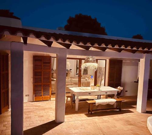een witte tafel en bank op een patio 's nachts bij Villa mit Meerblick und Pool für 6 Personen in Santanyi