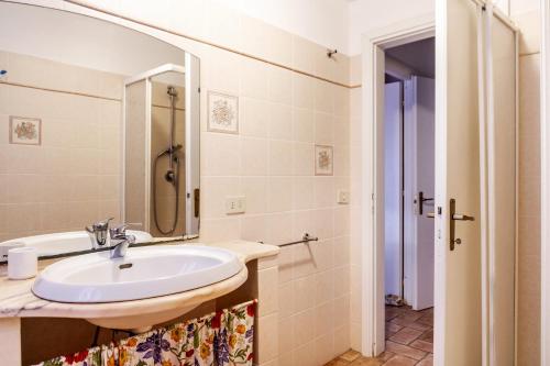 un bagno con lavandino e specchio di Casa Attila a Castiglione della Pescaia