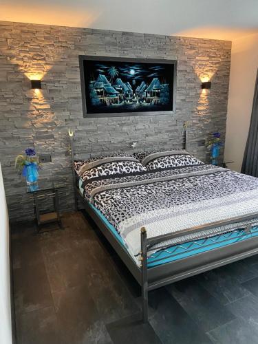 a bedroom with a bed and a stone wall at Residenza San Remy in Unterkulm