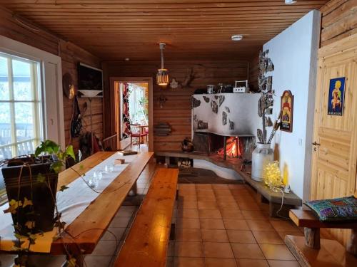 sala de estar con mesa y chimenea en Nauti luonnon rauhasta Jataniemen Uittotuvassa. en Kajaani