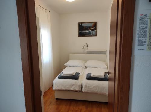 een slaapkamer met een bed met 2 kussens bij Apartment Joy II in Šibenik