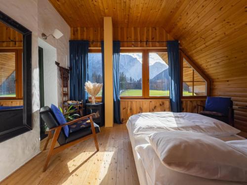 a bedroom with a bed and a large window at Hiša Ojstrica in Solčava