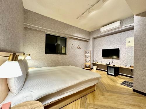 Habitación de hotel con cama grande y TV en 茗居 House, en Taichung