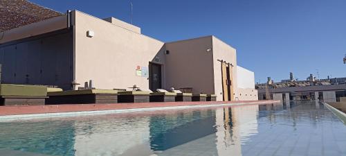 a swimming pool with chairs next to a building at Hotel Orangine in Hospitalet de Llobregat