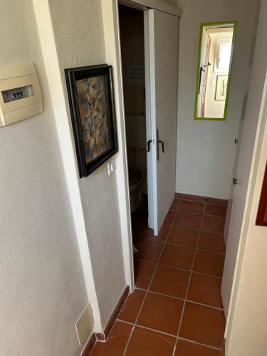a hallway with a tile floor and a door with a painting at La Masa in Èze