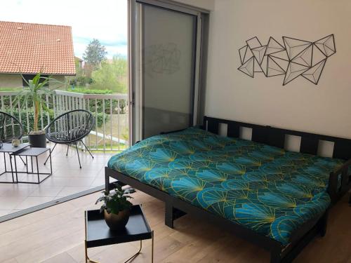 Cama en habitación con balcón en Studio Moderne, Terrasse et Parking en Romans-sur-Isère
