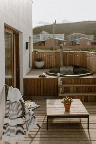 a wooden deck with a bench and a table at Yzers Boat House in Yzerfontein