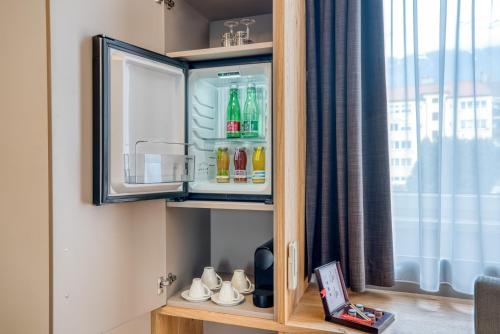 a cupboard with drinks in it next to a window at Leipziger Hof Innsbruck in Innsbruck