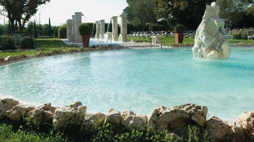 ein Pool mit einem Eisbärenbrunnen in einem Park in der Unterkunft Hotel Salus Terme - Adults Only in Viterbo