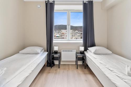 2 camas en una habitación con ventana en Forenom Serviced Apartments Bergen Skottegaten, en Bergen