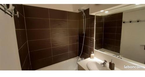 een badkamer met een bad, een wastafel en een spiegel bij Studio Puy saint vincent 1600 in Les Prés