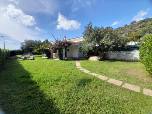 a yard with two chairs and a house at Nuova Valmar "Villa Borla" in Costa Rei