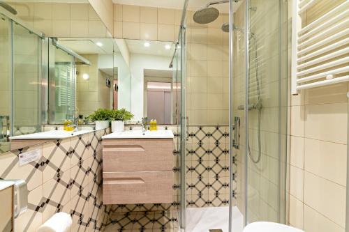 a bathroom with two sinks and a shower at Habitat Apartments Born in Barcelona