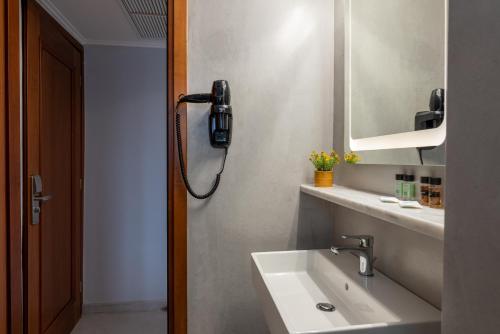 a bathroom with a sink and a phone on the wall at Poseidonio in Piraeus