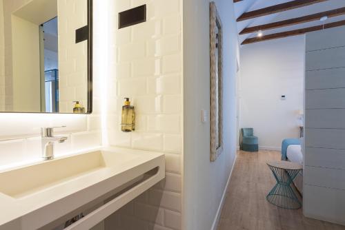 a bathroom with a sink and a mirror at Madeinterranea Suites in Málaga