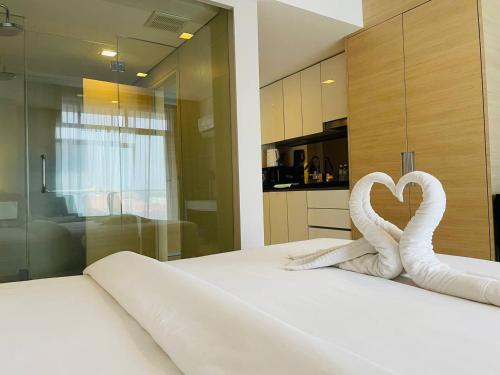 a bedroom with two swans in the shape of a heart at Melaka The Straits Residence in Malacca