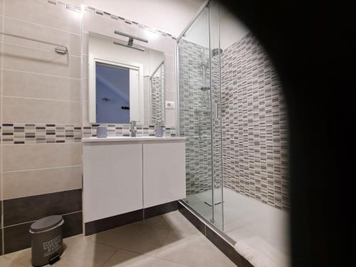 a bathroom with a sink and a glass shower at La Rosa Affittacamere in La Caletta