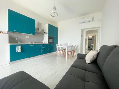 sala de estar con sofá y cocina con armarios azules en Terrazza sui Trabocchi, en Marina di San Vito