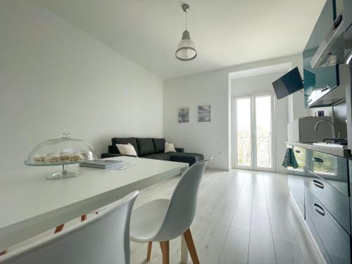 a white kitchen and living room with a table and chairs at Terrazza sui Trabocchi in Marina San Vito