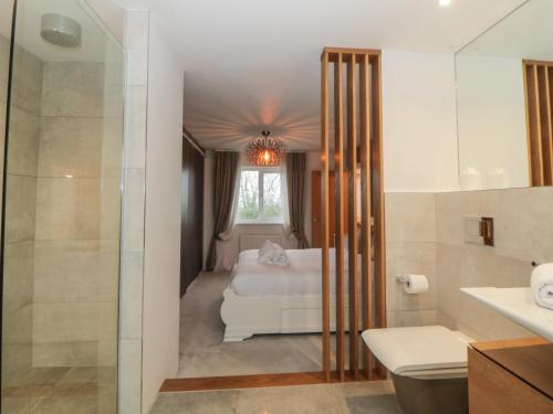 a bathroom with a bed and a shower and a sink at 2 White Rock Court in Paignton