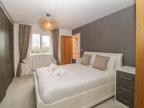 a bedroom with a white bed and a window at 2 White Rock Court in Paignton