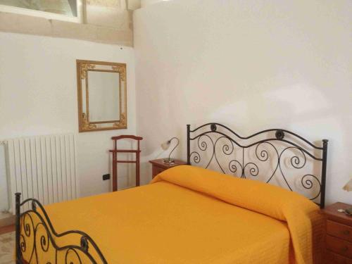 a bedroom with a bed with an orange blanket at B&B Regina Maria in Lecce