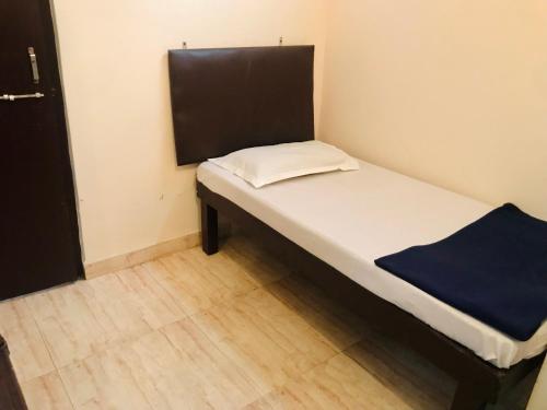 a small bed in a room with a wooden floor at Hotel Diamond in Secunderabad