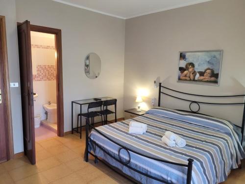 a bedroom with a bed and a bathroom with a toilet at Villa Eleila Affittacamere in Terracina