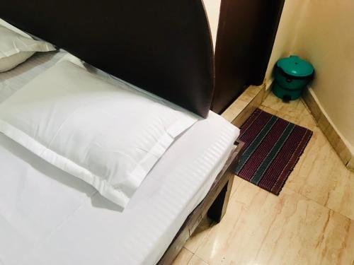 a white bed with a black box on top of it at Hotel Diamond in Secunderabad