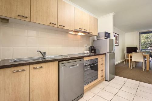 a kitchen with a sink and a refrigerator at Quest St Kilda Bayside in Melbourne