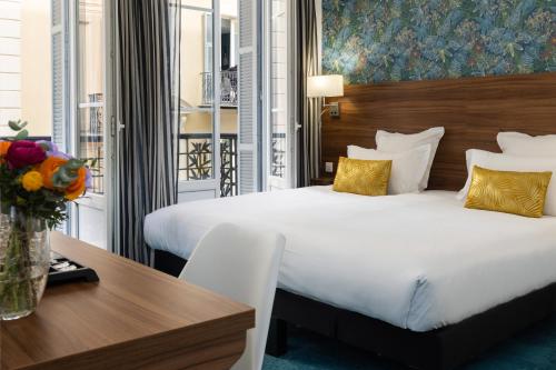 a hotel room with a large bed and a table at Hotel Khla Nice in Nice