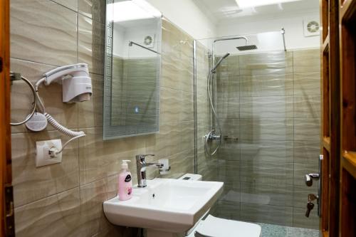 a bathroom with a sink and a shower at Alsara Guesthouse in Gjirokastër