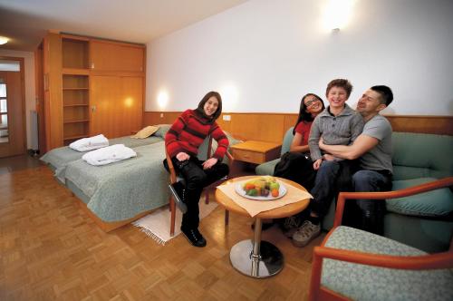 um grupo de pessoas sentadas num quarto de hotel em Terme Banovci - Hotelsko naselje Zeleni gaj em Banovci