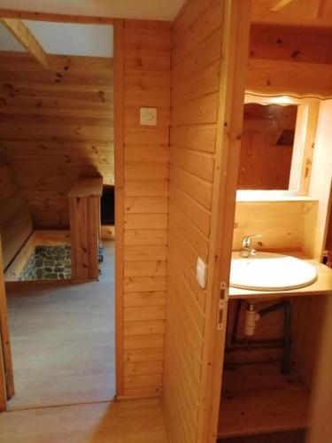 une salle de bain avec un lavabo dans une cabane en rondins dans l'établissement Maison vue Montagne avec jardin, à Oz
