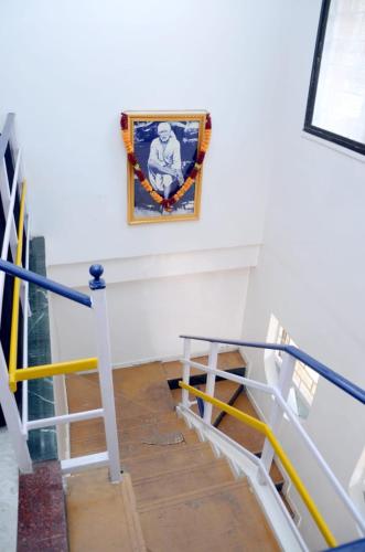 a stairway with a painting on the wall and a flag at Hotel Sairam Lodge in Nashik
