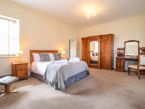 a bedroom with a large bed and a mirror at Henstead Hall East in Beccles