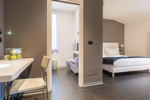 a bedroom with a bed and a bathroom with a mirror at Hotel Metropolitan in Bologna
