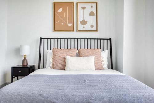 1 dormitorio con 1 cama con almohadas rosas en Luxury Fort Point 1BR w WD Gym BOS-488, en Boston