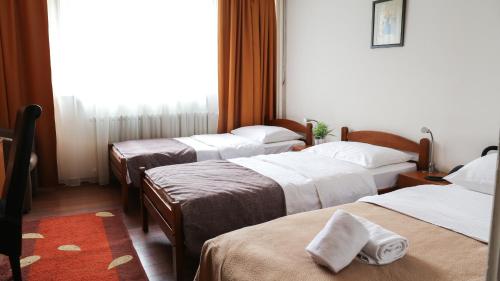 a group of three beds in a hotel room at Hotel Srbija in Belgrade