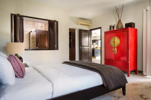 1 dormitorio con armario rojo y cama en Paseo Luxury Suites, en Playa del Carmen