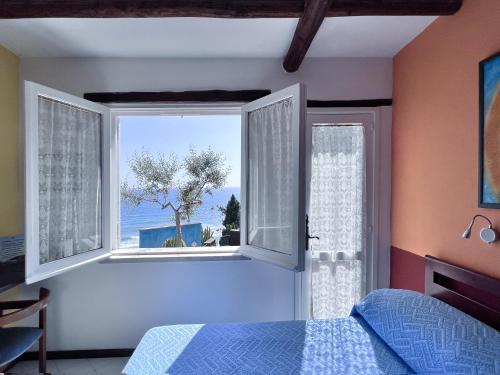 a bedroom with a window with a view of the ocean at Aeneas' Landing Resort in Gaeta