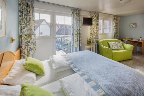 ein Schlafzimmer mit einem Bett, einem Stuhl und einem Fenster in der Unterkunft Landhotel Restaurant zur Krone in Gottenheim