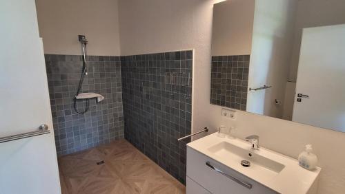a bathroom with a sink and a shower with a mirror at Hotel Lethehof in Wardenburg